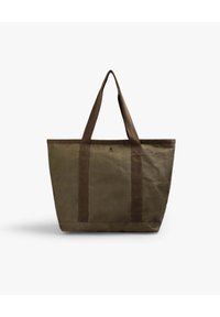 Bolsa de lona en verde oliva, con dos asas marrones resistentes, forma rectangular y un sutil detalle de logo en la parte frontal.
