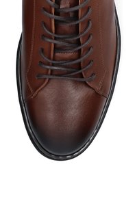 Brązowe skórzane buty z czarnymi sznurowadłami, zaokrąglonym noskiem i gładką teksturą. Posiadają kontrastowe przeszycia oraz delikatny połysk na powierzchni.