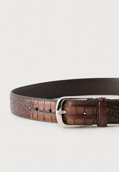 Ceinture en cuir marron à motif crocodile avec boucle en métal argenté, plusieurs trous de réglage et bords cousus sur fond blanc.