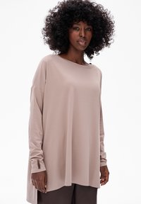 Lichtbeige lange mouwen top met een ontspannen pasvorm, brede halslijn en iets gestructureerde stof. Heeft een subtiele logotag bij de manchet.