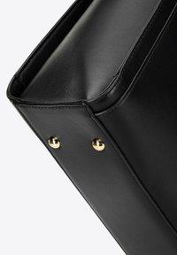 Borsa in pelle nera con un design strutturato, bordi arrotondati e dettagli in hardware dorato. Texture liscia con cuciture visibili e rivetti.
