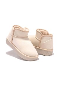 Botas beige de suave ante con un interior aterciopelado, que presentan un diseño de tobillo bajo, punta redondeada y suela de goma texturizada.