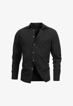 Fekete, galléros ing, textúrált anyagból készült, hosszú ujjakkal, mellzsebbel és barna gombokkal az elején.