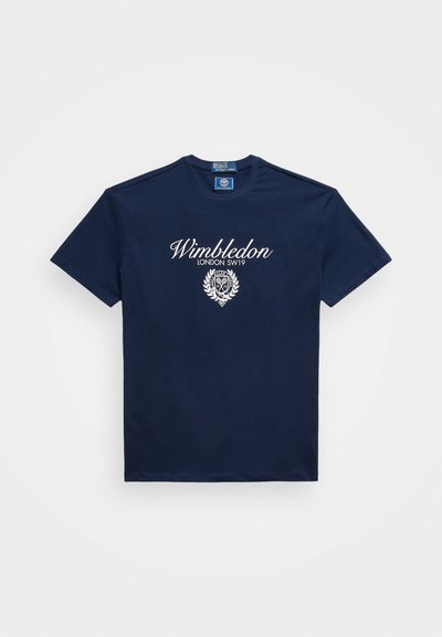 Σκούρο μπλε βαμβακερό t-shirt με λευκό κείμενο "Wimbledon LONDON SW19" και έμβλημα στο κέντρο, κοντά μανίκια και στρογγυλή λαιμόκοψη.