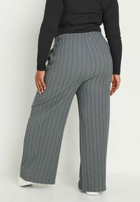 Breda, grå ribbade byxor med vertikala ränder, med en avslappnad passform och elastisk midja för komfort. Slät textur med mjukt tyg.