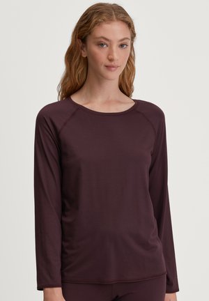 Langshirt in donker bordeaux stof, met een ronde hals en raglanmouwen, met een gladde, rekbare textuur.