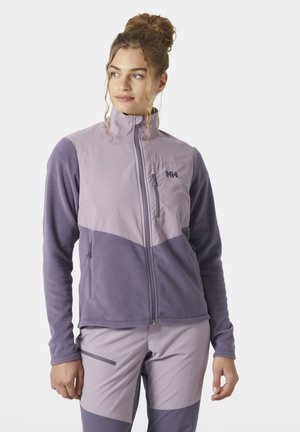 Chaqueta de forro polar en púrpura claro y oscuro, con cremallera completa, cuello alto, bolsillo en el pecho y diseño de bloques de color curvados.