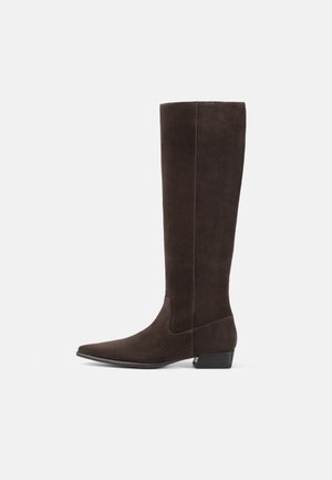Bottes en suède marron jusqu'au genou avec un bout pointu et un petit talon bloc. Texture lisse, couture minimale et sans matériel ou accents proéminents.