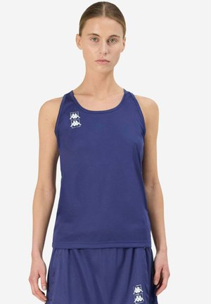 Femme portant un haut de sport bleu marine sans manches et une jupe assortie, tous deux ornés d'un logo blanc sur la partie supérieure de la poitrine et en bas de la jupe.