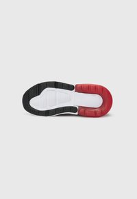 Sula design med svart gummi vid hälen, röda accenter vid tån, och en vit mellansula med texturerad yta och mönstrad sula.