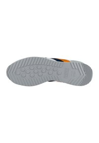 Suela de zapato de goma gris con un patrón texturizado. Presenta agarres circulares y estrías horizontales, con la marca "Munich desde 1983".