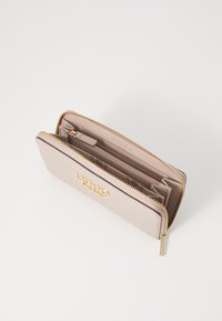 Portafoglio in pelle beige con hardware dorato; chiusura a zip, multiple fessure per carte e superficie testurizzata; logo impresso sul davanti.