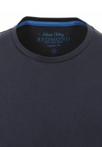 Mørkeblå bomulds t-shirt med rund hals, der har en ensartet struktur. Indersiden af kraven har en kontrastfarvet blå accent. Mærket "Redmond", størrelse M.
