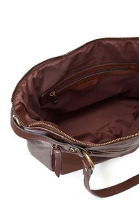 Bruine leren handtas met een ritssluiting aan de bovenkant. Het interieur beschikt over een enkele ritszak en een gladde stofvoering, met getextureerde hardwareaccents.