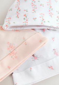 Trois bonnets pour bébé en coton doux. Couleurs : rose clair, blanc avec motifs floraux, et blanc avec dessins de fées. Chacun possède un revers plié.