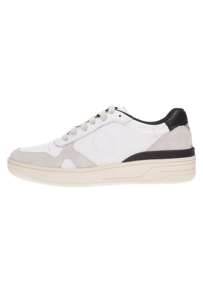 Zapatilla blanca con detalles en gris y talón negro. Presenta una parte superior de cuero suave, detalles en ante y una suela de goma texturizada.
