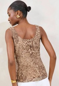 Brown patterned sleeveless top featuring a round neckline and smooth texture, with light and dark brown abstract designs.
