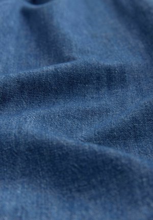 Denimstoff in tiefblau, mit einer glatten Textur und leichten Variationen, die subtile gewebte Muster und ein sanftes Drapierungsaussehen zeigen.