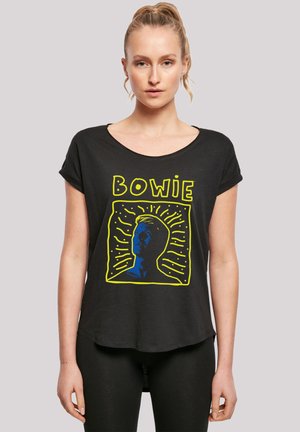 Black t-shirt with short rolled sleeves featuring a blue graphic of a person's face and "BOWIE" in yellow, set against a light background.