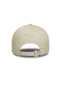 Beige caps med en rund form, glatt stoff, justerbar stropp bak, og ventilasjonsluftehull på sidene.