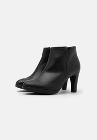 Mustat nahka ankle bootit, joissa on sileä pinta, pyöristetty kärki ja 5 cm:n blokkikorko. Varustettu sivuvetoketjulla helppoa pukemista varten.