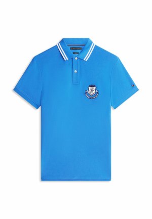 Polo azul de manga corta con doble rayas blancas en el cuello, dos botones en la tapeta y parche con el logo de Tommy Hilfiger en el pecho y la manga.