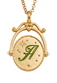 Gold pendant necklace with a green letter "A," adorned with small stars and two white pearls. Features a decorative heart motif above.