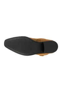 Chaussure en suède marron avec une semelle en caoutchouc noir texturé, présentant une forme pointue et des coutures soignées le long du bord.
