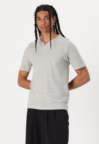 Grå kortærmet t-shirt med henley-udskæring, prydet med tynde vandrette striber og en knapdetalje, lavet af et blødt, glat stof.