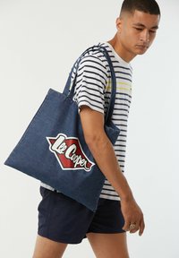 Denim-Shopper mit einem großen rot-weißen "Lee Cooper"-Logo, ausgestattet mit stabilen Schulterträgern und rechteckiger Form.