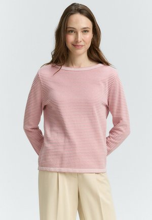 T-shirt rose clair à manches longues avec des rayures horizontales, décolleté rond et tissu texturé. Associé à un pantalon beige pour un look simple.