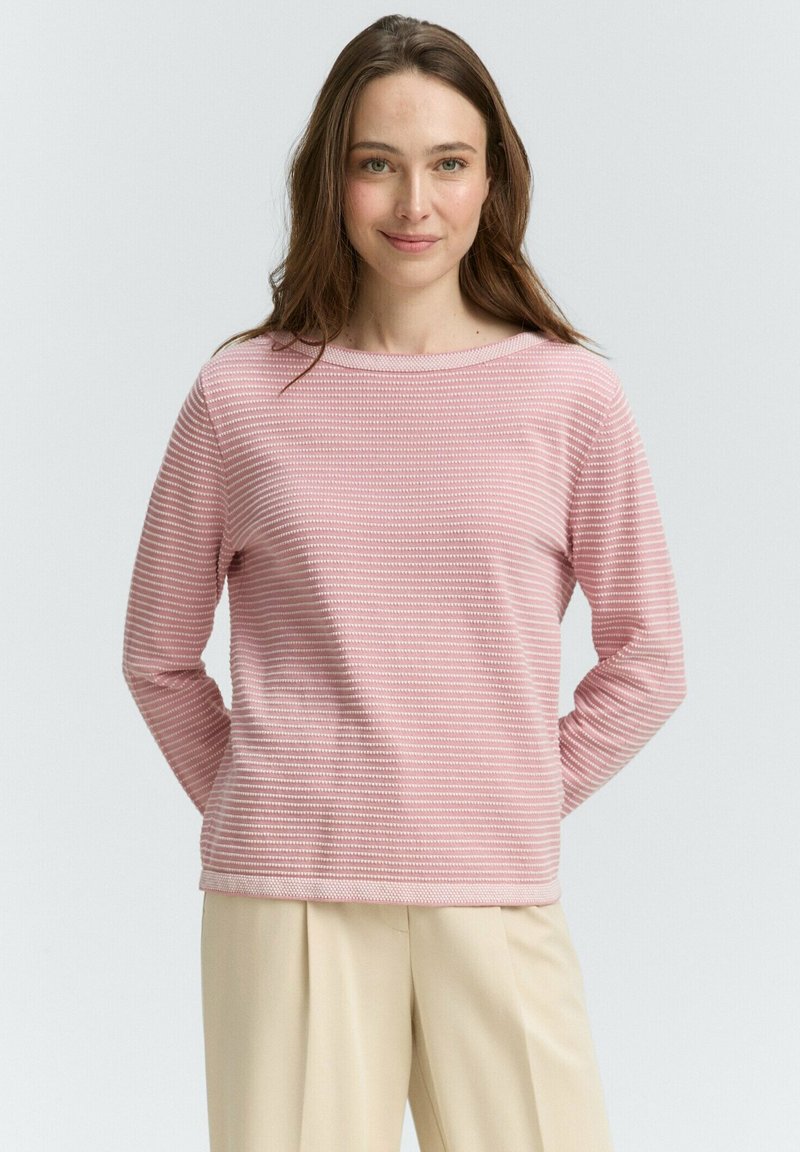 Lichtroze, lange mouw top met horizontale strepen, ronde halslijn en gestructureerde stof. Gecombineerd met beige broeken voor een eenvoudige look.