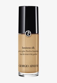 Giorgio Armani Luminous Silk foundation i en klar glassflaske med svart hette. Beigefarget væske inni, med merkevaretekst og logo.