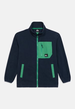Námořnicky modrá fleecová bunda se zeleným zipem, zelenou náprsní kapsou na zip a dvěma bočními kapsami se zeleným lemováním, dlouhými rukávy a stojáčkovým límcem.