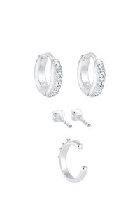 Pendientes de aro plateados con cristales transparentes, pendientes de botón redondos y un anillo de puño abierto. Todas las piezas presentan un acabado pulido.