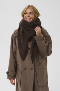 Brązowy wełniany szalik owinięty wokół szyi, miękka faktura, trójkątny kształt, noszony z pasującym brązowym płaszczem z dużymi kieszeniami i guzikami.