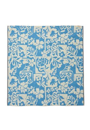 Blåt og hvidt håndklæde med et indviklet blomstermønster, der indeholder forskellige blomster og blade arrangeret i et gentaget design.