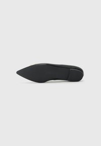 Chaussure noire à bout pointu avec une semelle en caoutchouc texturée, dotée d'un petit talon et d'un détail en accent doré sur le dessus. Finition en matériau lisse.