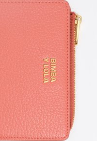 Koralivärviline nahkrahakott tekstuuriga viimistlusega, millel on kuldne logo "BIMBA Y LOLA" ning kuldsete detailidega lukuga sulgemine.