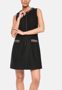 Schwarzes ärmelloses Kleid mit rundem Ausschnitt, Leopardenmuster-Akzenten an den Taschen und am Kragen sowie einem Reißverschluss vorne.