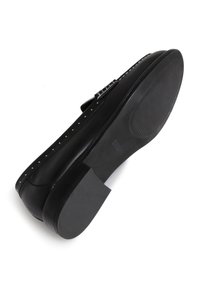 Zapato de cuero negro con punta redondeada, suela plana, detalles de clavos plateados a lo largo del borde y un acento de hebilla en la correa. Suela de goma texturizada.