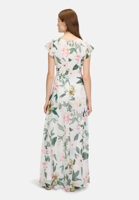 Maxi sukienka z lekkiej, przezroczystej tkaniny z kwiecistym wzorem w różowe i zielone kwiaty na białym tle. Falbaniaste rękawki i dopasowana talia.