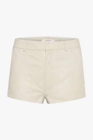 Beżowe skórzane szorty o gładkiej fakturze, z dopasowanym pasem, szlufkami na pasek i subtelnym przeszyciem z przodu. Prosty, współczesny design.