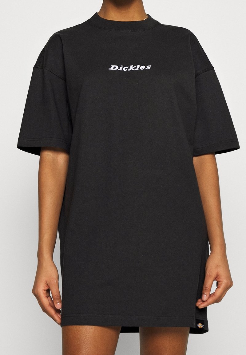 Svart bomullst-shirtklänning med rundad halsringning, korta ärmar och en vit "Dickies"-logotyp på framsidan. Avslappnad, loose fit.