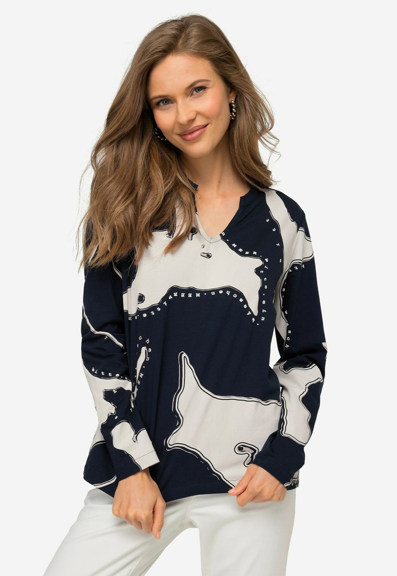 Maglietta a maniche lunghe blu navy con scollo a V, caratterizzata da un motivo astratto beige chiaro in contrasto, contornato di nero. Tessuto morbido.
