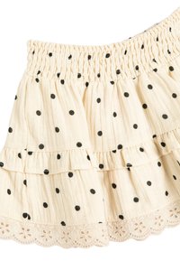 Gonna a strati di colore crema realizzata in tessuto morbido con pois neri, dotata di una vita arricciata e di una finitura in pizzo all'orlo.