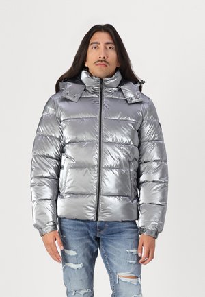 Chaqueta de plumas plateada metálica con cuello alto, cierre de cremallera y capucha desmontable. Presenta puños acanalados y diseño acolchado.
