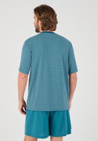 Camisa de manga corta a rayas en color verde azulado con cuello redondo, combinada con pantalones cortos sólidos en el mismo color. La tela parece ligera y suave.