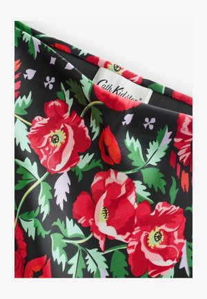 Schwarzer Stoff mit einem lebhaften Blumenmuster, bestückt mit großen roten Rosen und grünen Blättern, akzentuiert durch kleine lila und rosa Details. Markenetikett sichtbar.