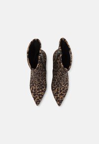 Bottes de cheville en imprimé léopard avec bouts pointus, en tissu doux et avec des fermetures éclair sur les côtés. Présente une finition texturée dans des tons de marron et de noir.